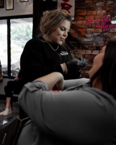 Piercing shop near me showing a piercer at american tattoo society of Fayetteville Ft Bragg pierces a client off base